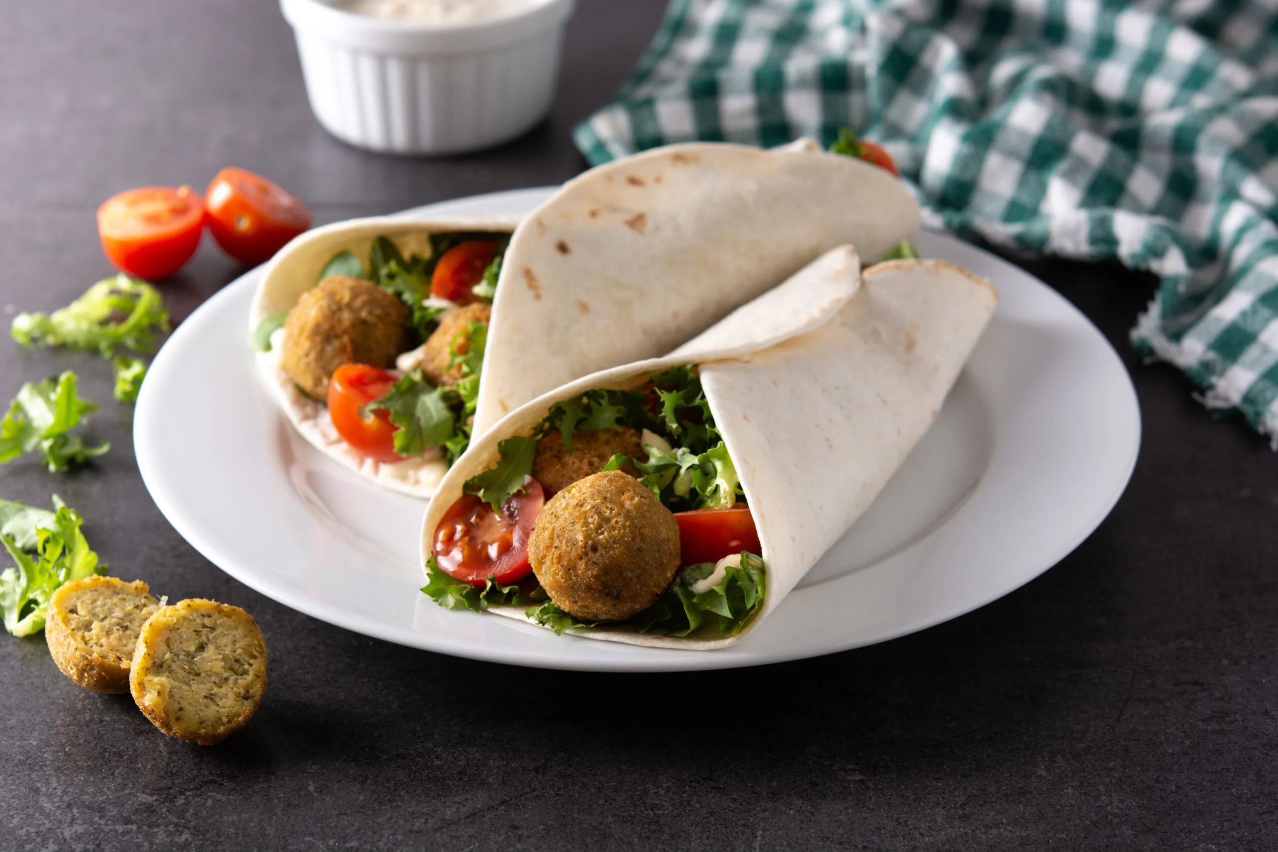 Friss falafel golyók pitában tálalva friss zöldségekkel és tahini szósszal, közel-keleti street food stílusban