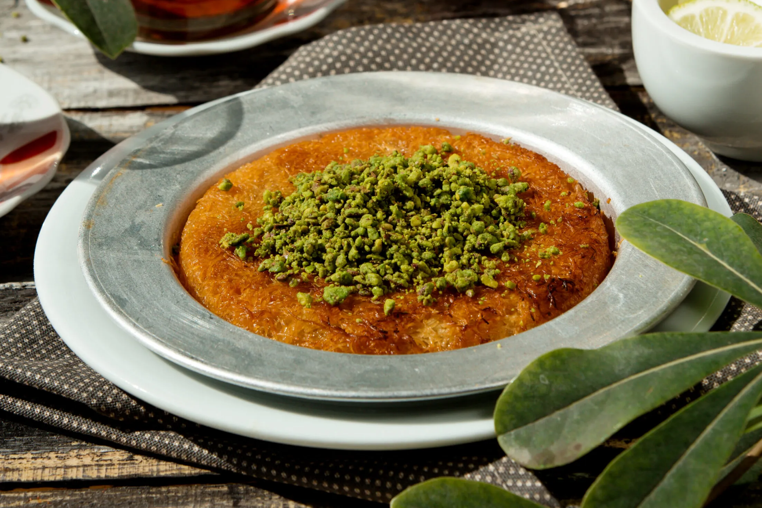 Közel-keleti kunafa desszert olvadt sajttal, ropogós tésztával és pisztáciával díszítve