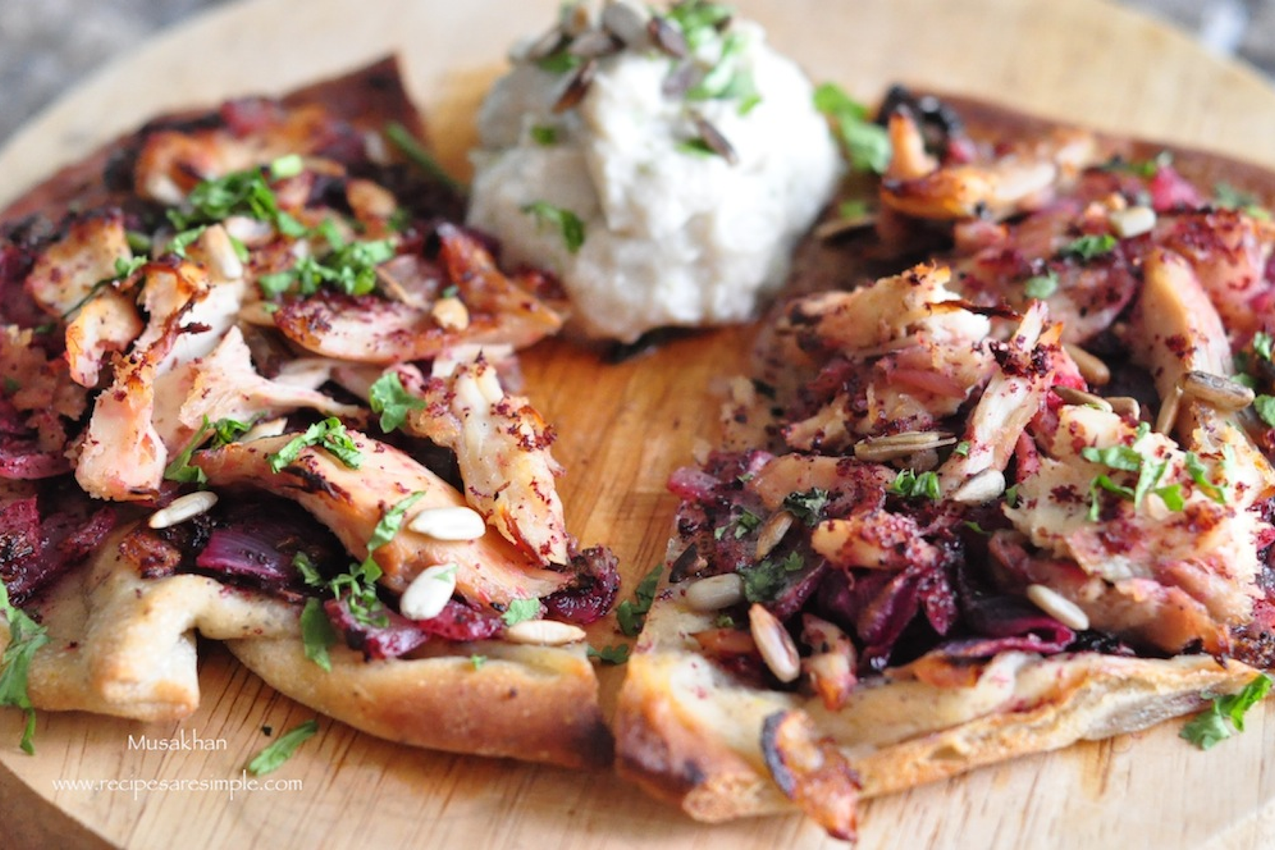 Hagyományos palesztin musakhan étel csirkével, karamellizált hagymával és taboon kenyéren tálalva